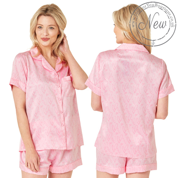 Pink drawn heart print satin pjs set and they consist of a shirt style top with a collar, top pocket and button up front and short sleeves with matching shorts with an elasticated waist band. In UK size 10, 12, 14, 16, 18, 20