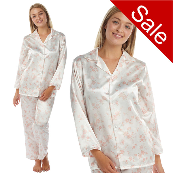ivory background with a peach/pink floral print silky shiny satin pjs set consisting of a shirt style top with full length sleeves, a collar, top pocket and a button up front with matching full length trousers in UK sizes 10, 12, 14