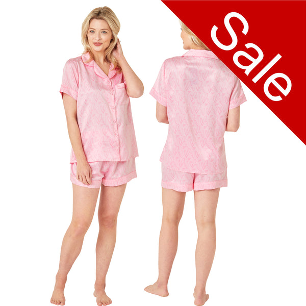 Pink drawn heart print satin pjs set and they consist of a shirt style top with a collar, top pocket and button up front and short sleeves with matching shorts with an elasticated waist band. In UK size 10, 12, 14, 16, 18, 20