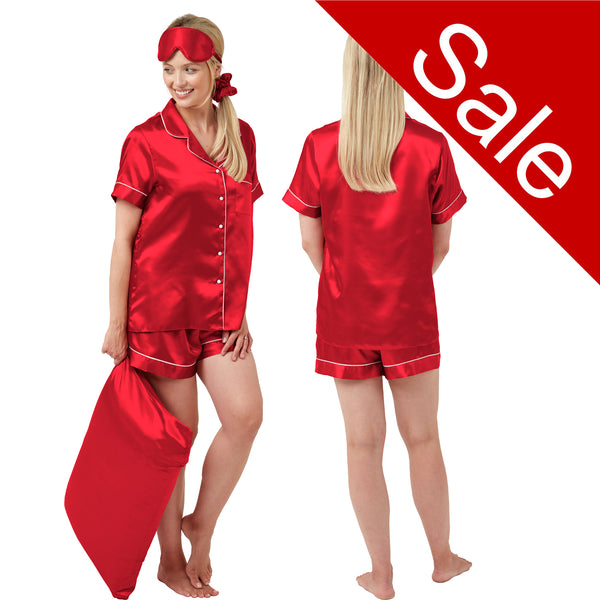 Red plain shiny satin pjs set consisting of a shirt style top with a collar, top pocket and button up front and short sleeves with matching shorts with an elasticated waist band. The pjs also come with a matching pillow case, eye mask and bobble.  In UK size 14, 16, 18, 20