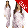 pink background with a darker pink poppy floral print silky shiny satin pjs set consisting of a shirt style top with full length sleeves, a collar, top pocket and a button up front with matching full length trousers in UK sizes 12, 14
