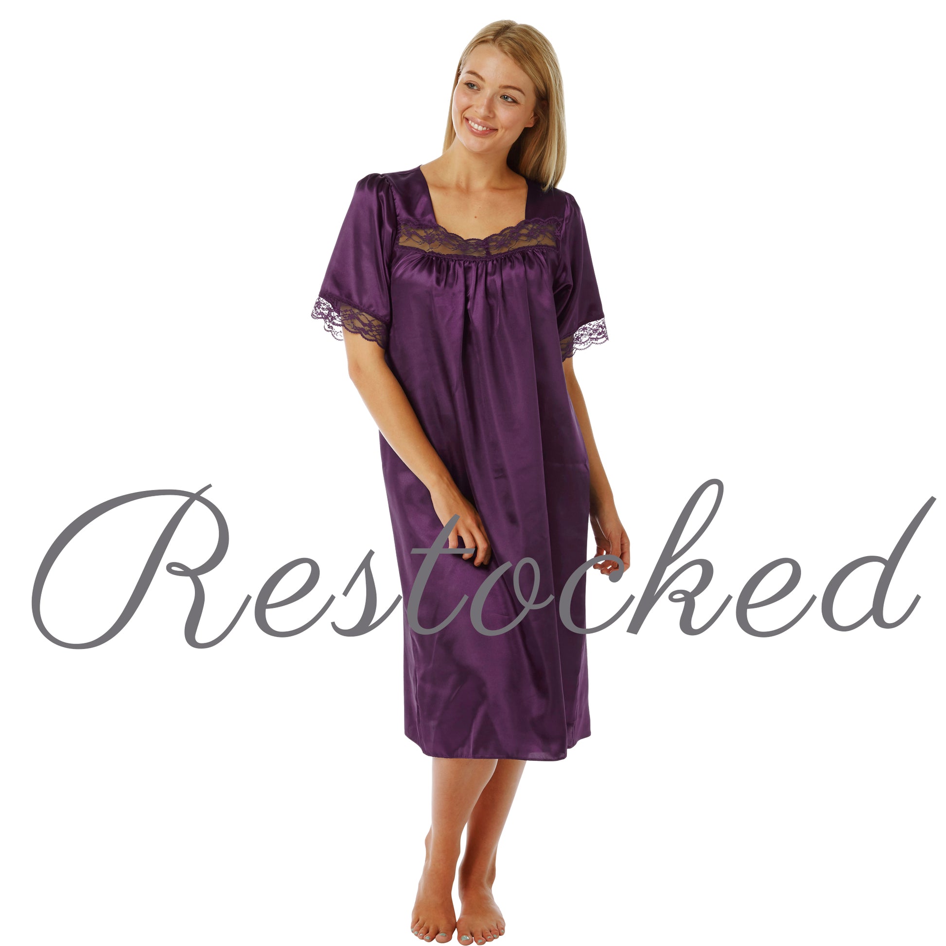 plain cadbury purple shiny silky satin classic style mid length nightdress which is straight in fit with gathered fabric to the chest and elbow length sleeves. The chest and sleeves are trimmed with floral lace and it it available in UK plus sizes 8, 10, 12, 14, 16, 18, 20, 22, 24, 26, 28, 30, 32, 34