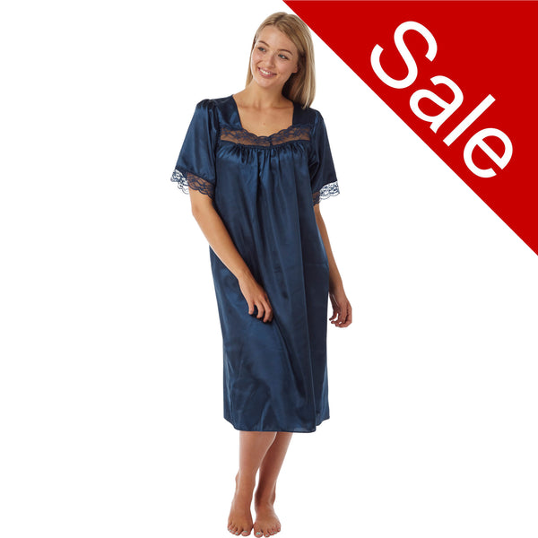plain navy blue shiny silky satin classic style mid length nightdress which is straight in fit with gathered fabric to the chest and elbow length sleeves. The chest and sleeves are trimmed with floral lace and it it available in UK sizes 8, 10, 12, 14, 16, 18, 