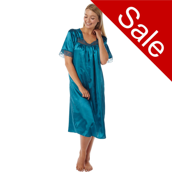 plain teal blue shiny silky satin classic style mid length nightdress which is straight in fit with gathered fabric to the chest and elbow length sleeves. The chest and sleeves are trimmed with floral lace and it it available in UK sizes 8, 10, 16, 18, 